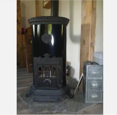 an old black stove sitting in a room at Casa Mia in Saint-Gervais-les-Bains
