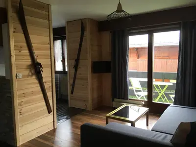 a living room with a couch and a large window at Les Esserts in Les Houches