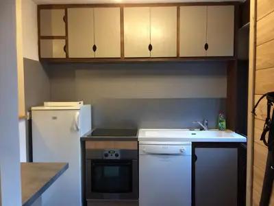 a kitchen with a white refrigerator and a sink at Les Esserts in Les Houches