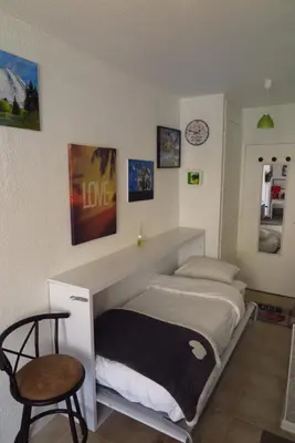 a bedroom with a bed and a chair in it at Art Studio in Chamonix-Mont-Blanc