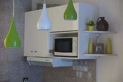 a kitchen with white cabinets and green pendant lights at Art Studio in Chamonix-Mont-Blanc