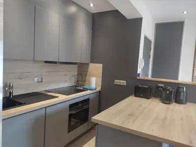 a kitchen with white cabinets and a wooden counter top at Central Sweet Home in Saint-Gervais-les-Bains