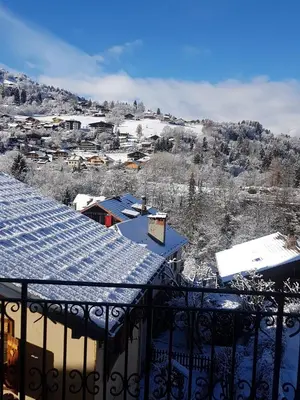 a view of a town in the snow from a balcony at Central Sweet Home in Saint-Gervais-les-Bains