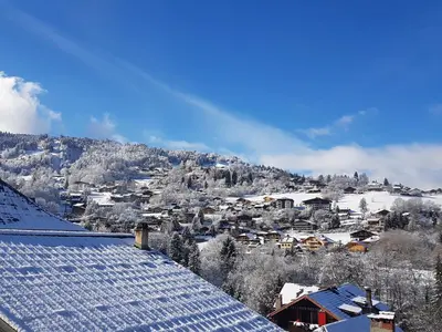 a snow covered city with a mountain in the background at Central Sweet Home in Saint-Gervais-les-Bains