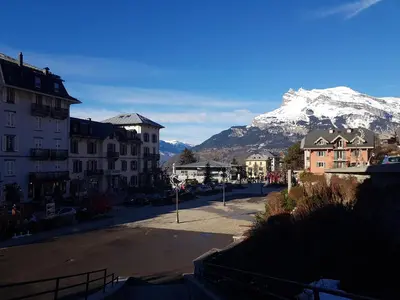 a street in a town with a mountain in the background at Central Sweet Home in Saint-Gervais-les-Bains