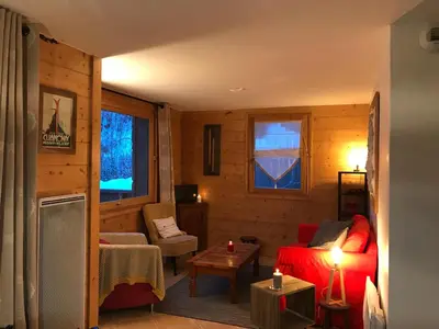 a living room with a red couch and a table at Kandahar in Les Houches