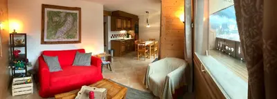 a living room with a red couch and a kitchen at Kandahar in Les Houches