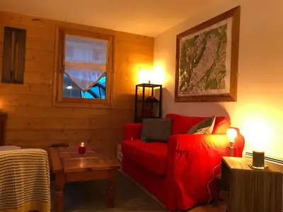 a living room with a red couch and a window at Kandahar in Les Houches