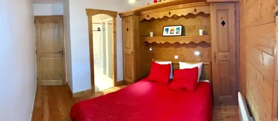 a bedroom with a red bed with red pillows at Kandahar in Les Houches