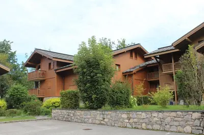 a building with a stone wall in front of it at Reine des Prés in Samoëns