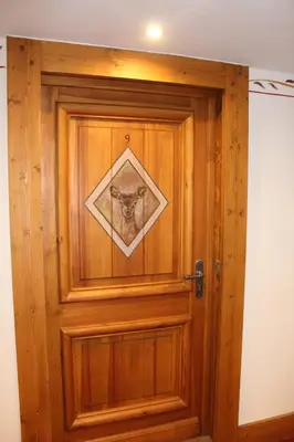 a wooden door with a picture of a dog on it at Reine des Prés in Samoëns