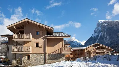 a log cabin in the mountains with snow on the ground at Reine des Prés in Samoëns