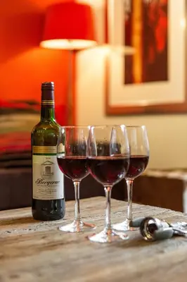 a bottle of wine and two glasses on a table at Biolay 1 in Chamonix-Mont-Blanc