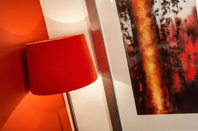 a red lamp next to a wall with a painting at Biolay 1 in Chamonix-Mont-Blanc