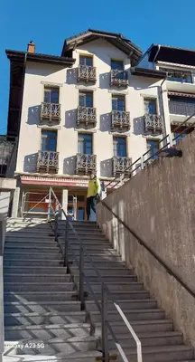 a man walking up the stairs in front of a building at Savran in Saint-Gervais-les-Bains