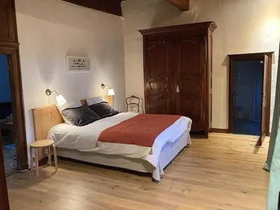 a bedroom with a large bed and a wooden floor at appartement château de la Comtesse in Saint-Gervais-les-Bains