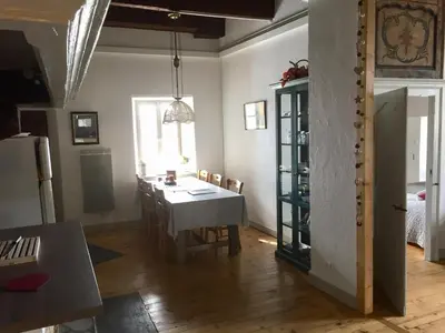 a kitchen and dining room with a table and a room with a refrigerator at appartement château de la Comtesse in Saint-Gervais-les-Bains
