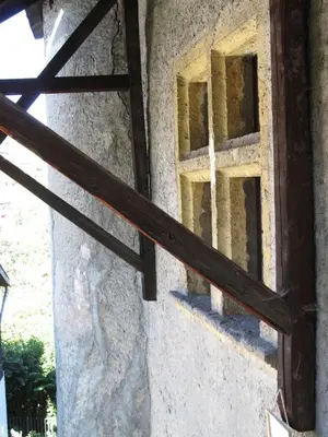 an open window in a stone building with a wooden rail at appartement château de la Comtesse in Saint-Gervais-les-Bains