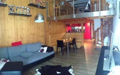 a living room with a couch and a table with chairs at Flaine Forum i1 Cassiopée Duplex Mezzanines & Terrasse in Flaine