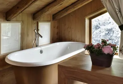 a white tub in a room with a window at Chalet des Fermes de Marie, avec services, Collection Chalets des Fermes in Megève