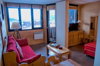 a bedroom with a bed with a red blanket and a mirror at Chamois in Chamonix-Mont-Blanc