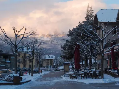 a city street with tables and chairs in the snow at Le Grand Panorama 5 Étage Balcon Vue sur La Montagne in Saint-Gervais-les-Bains