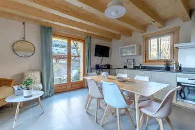 a kitchen and dining room with a wooden table and chairs at Le Chalet de l'Ours Blanc in Chamonix-Mont-Blanc