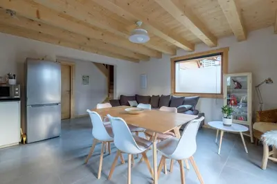 a kitchen and living room with a wooden table and chairs at Le Chalet de l'Ours Blanc in Chamonix-Mont-Blanc