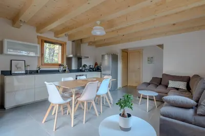 a kitchen and living room with a table and chairs at Le Chalet de l'Ours Blanc in Chamonix-Mont-Blanc