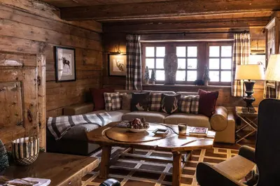 a living room with a couch and a table at Chalet Chatel, avec services, Collection Chalets des Fermes - Megève in Megève