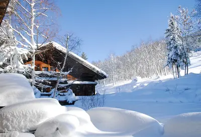 a log cabin covered in snow in front thereof at Chalet Chatel, avec services, Collection Chalets des Fermes - Megève in Megève