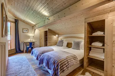 two beds in a room with wooden walls at Chalet Sanaz in Chamonix-Mont-Blanc