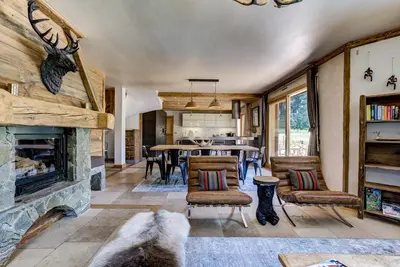 a living room with a fireplace and a dining room at Chalet Sanaz in Chamonix-Mont-Blanc