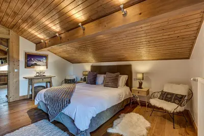 a bedroom with a large bed and a wooden ceiling at Chalet Sanaz in Chamonix-Mont-Blanc
