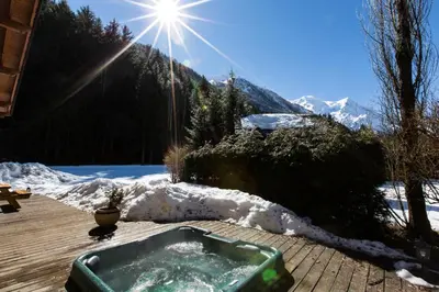 a hot tub sitting on a deck in the snow at Chalet Sanaz in Chamonix-Mont-Blanc