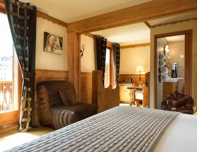 a bedroom with a bed and a chair at Auberge du Manoir in Chamonix-Mont-Blanc