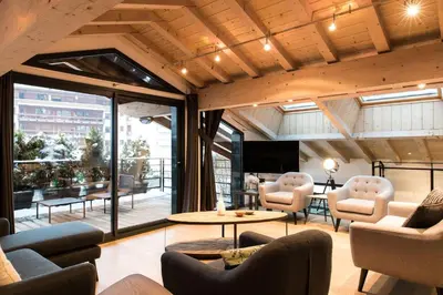 a lobby with chairs and tables and a large window at Chalet Belachat in Chamonix-Mont-Blanc