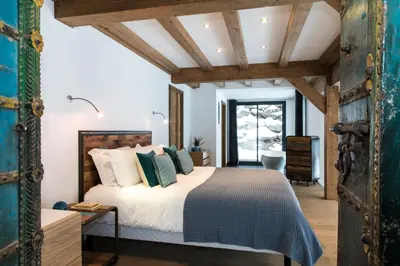 a bedroom with a king sized bed in a room with wooden ceilings at Chalet Belachat in Chamonix-Mont-Blanc