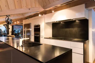a kitchen with a black counter top and wooden ceilings at Chalet Belachat in Chamonix-Mont-Blanc
