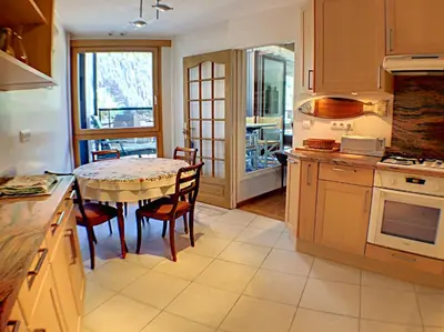 a kitchen with a table and chairs and a window at L'Outa Panoramique in Chamonix-Mont-Blanc