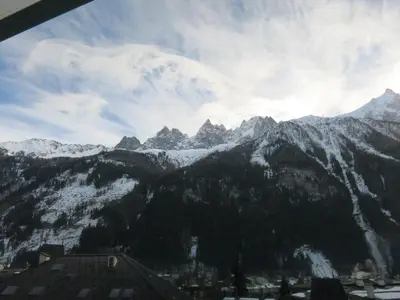 a chair in front of a window with a view at L'Outa Panoramique in Chamonix-Mont-Blanc