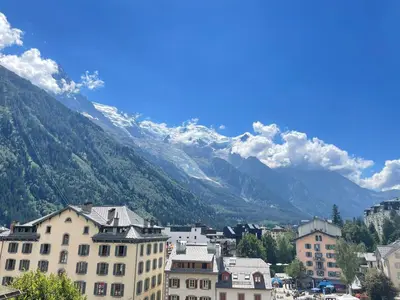 a city with buildings and mountains in the background at Hotel La Verticale in Chamonix-Mont-Blanc