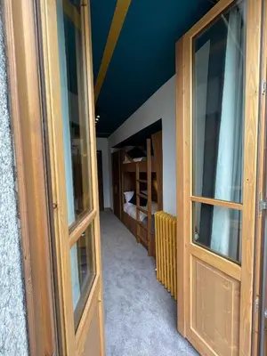 a room with two wooden doors and a room with shelves at Hotel La Verticale in Chamonix-Mont-Blanc