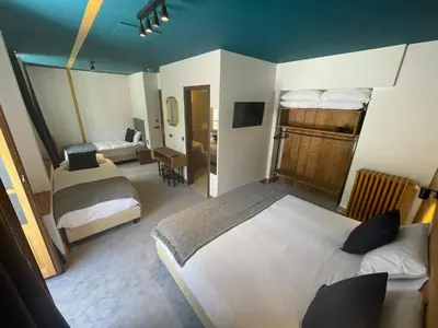 a hotel room with two beds and a desk at Hotel La Verticale in Chamonix-Mont-Blanc