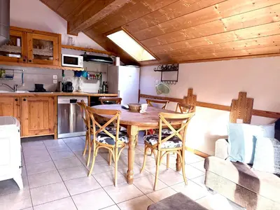 a dining room with a wooden table and a couch at Appartement Orion à Saint Gervais, proche Chamonix in Saint-Gervais-les-Bains