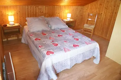 a bed in a room with two tables and a chair at Tifanlo in Samoëns