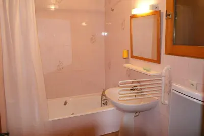 a white bathroom with a sink and a bath tub at Tifanlo in Samoëns