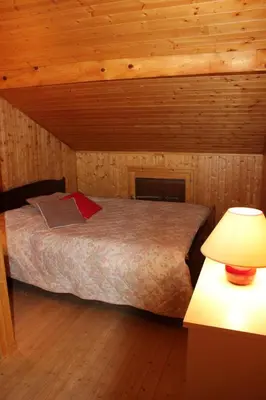 a bedroom with a bed in a wooden cabin at Tifanlo in Samoëns