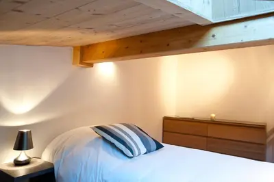 a bedroom with a white bed and a wooden ceiling at Quartz-Montblanc in Chamonix-Mont-Blanc
