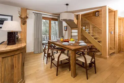 a dining room with a wooden table and chairs at Chalet des Souchettes - Chamonix All Year in Chamonix-Mont-Blanc
